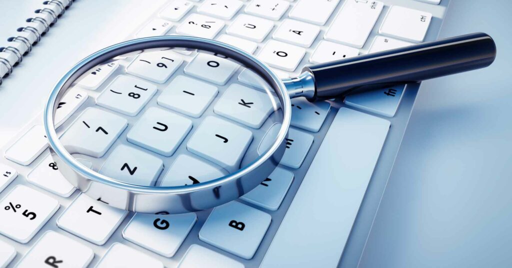 Image of a magnifying glass on a keyboard. 